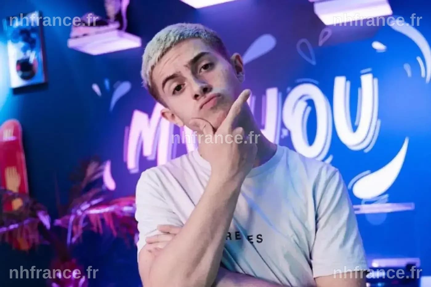 Michou en tenue streetwear avec cheveux colorés.
